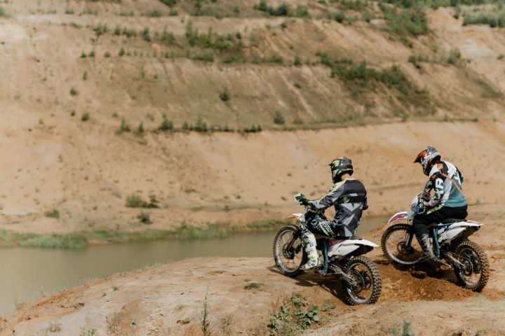 a man riding a motorcycle down a dirt road
