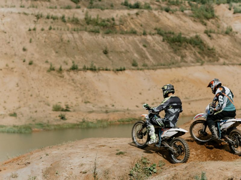 a man riding a motorcycle down a dirt road