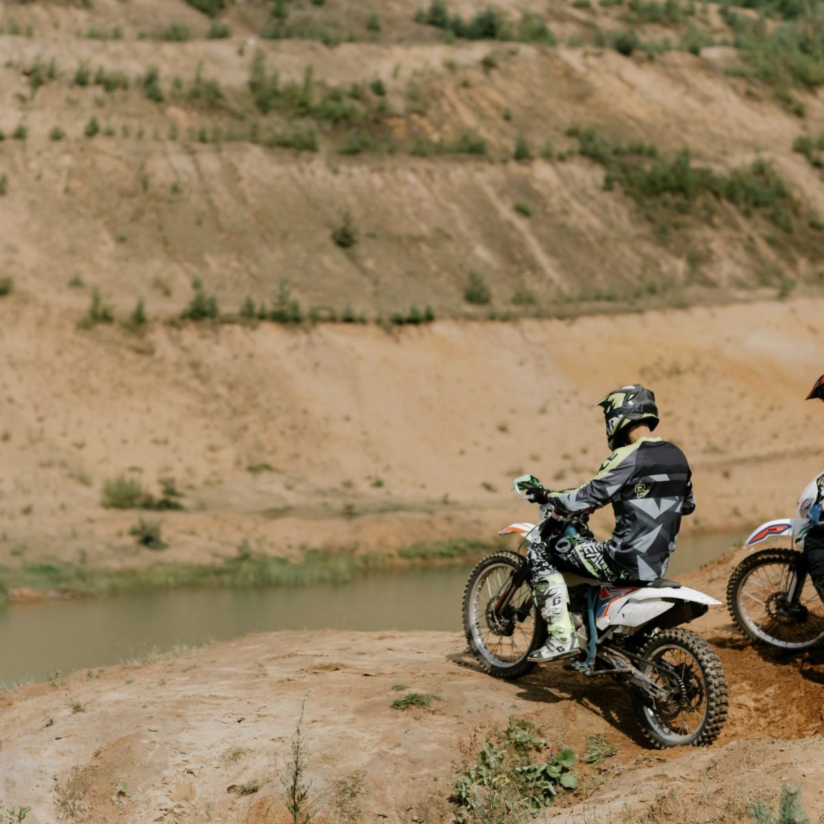 a man riding a motorcycle down a dirt road