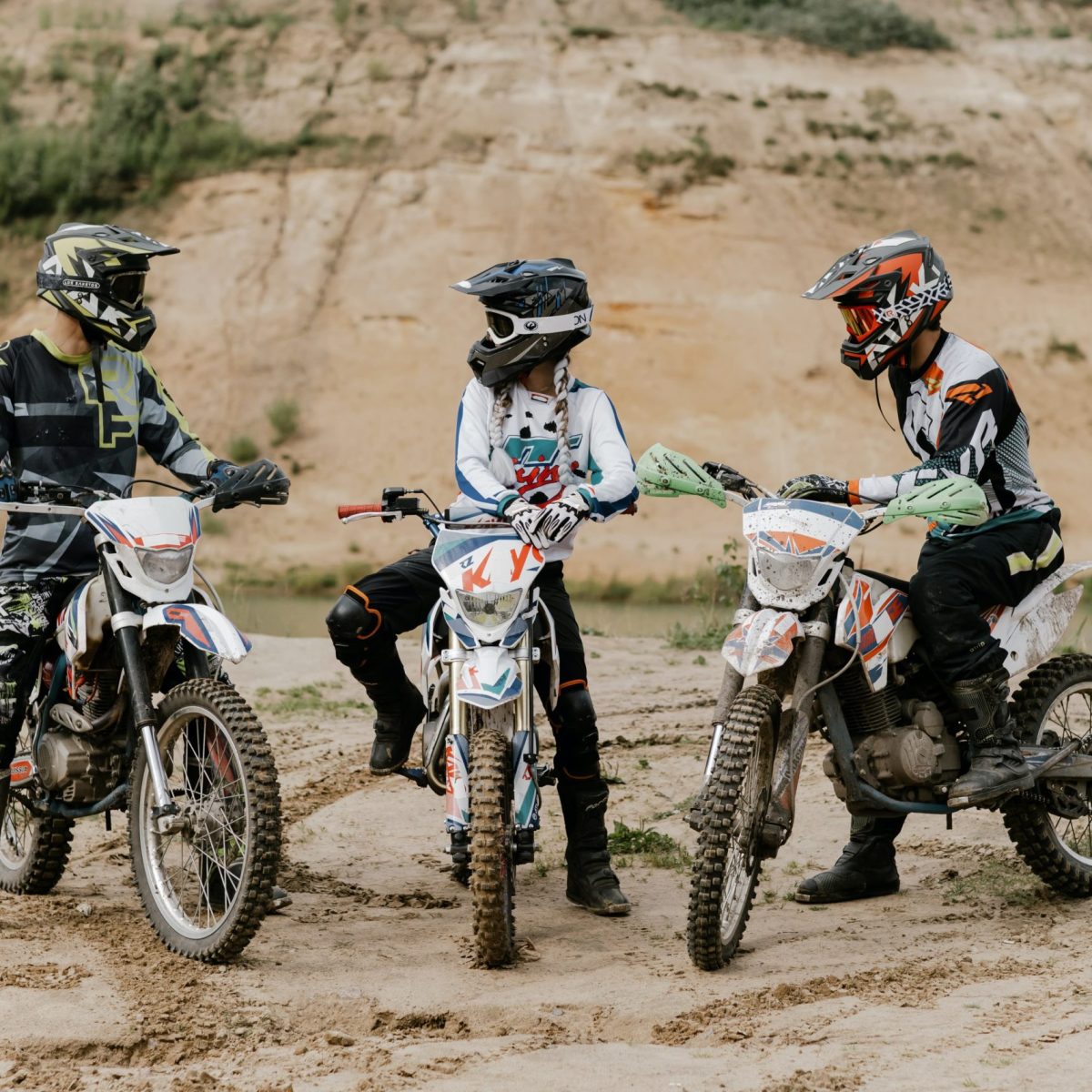 a man riding a motorcycle down a dirt road